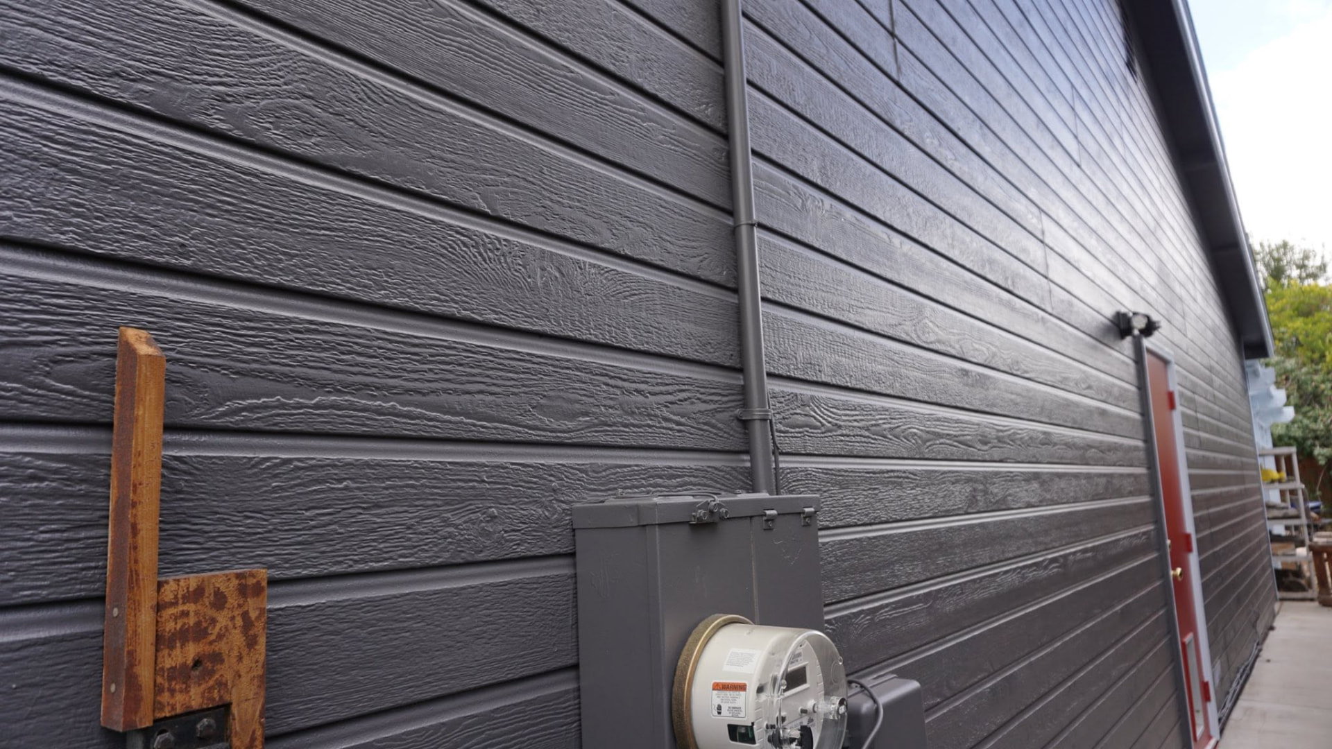 Exterior siding repaint in a modern charcoal