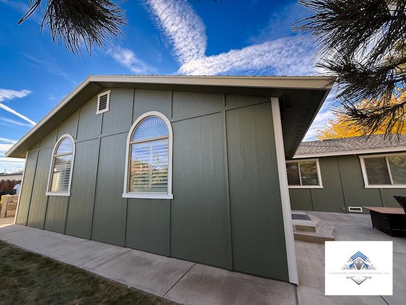 Shed and home exterior painted in sage green with white trim