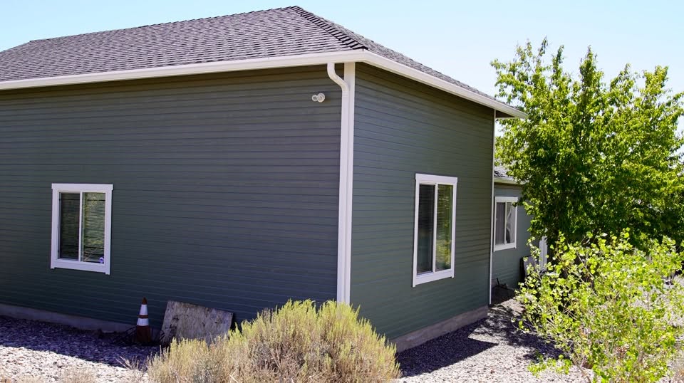 Lap siding repaint in a deep forest green with crisp white trim